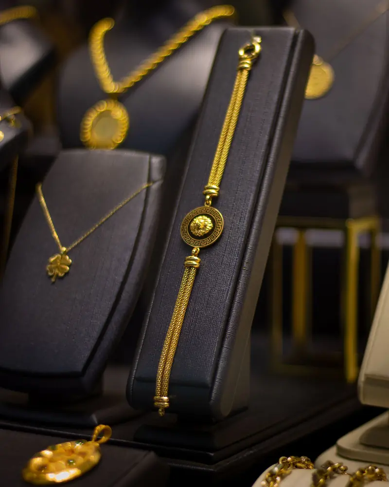 Gold necklaces and a bracelet on black display stands